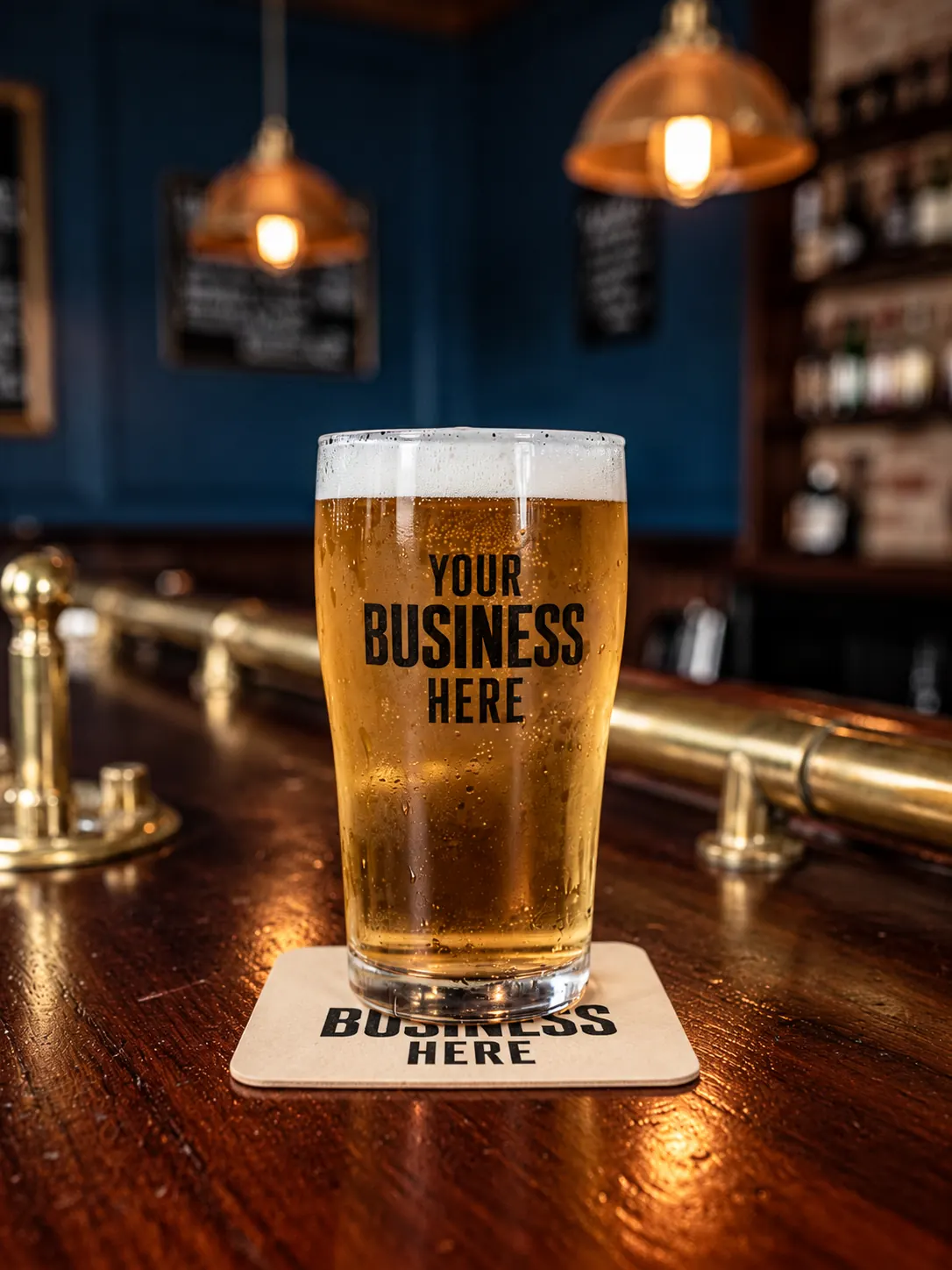 A pint glass and a coaster printed with “Your business here”, on a pub bar